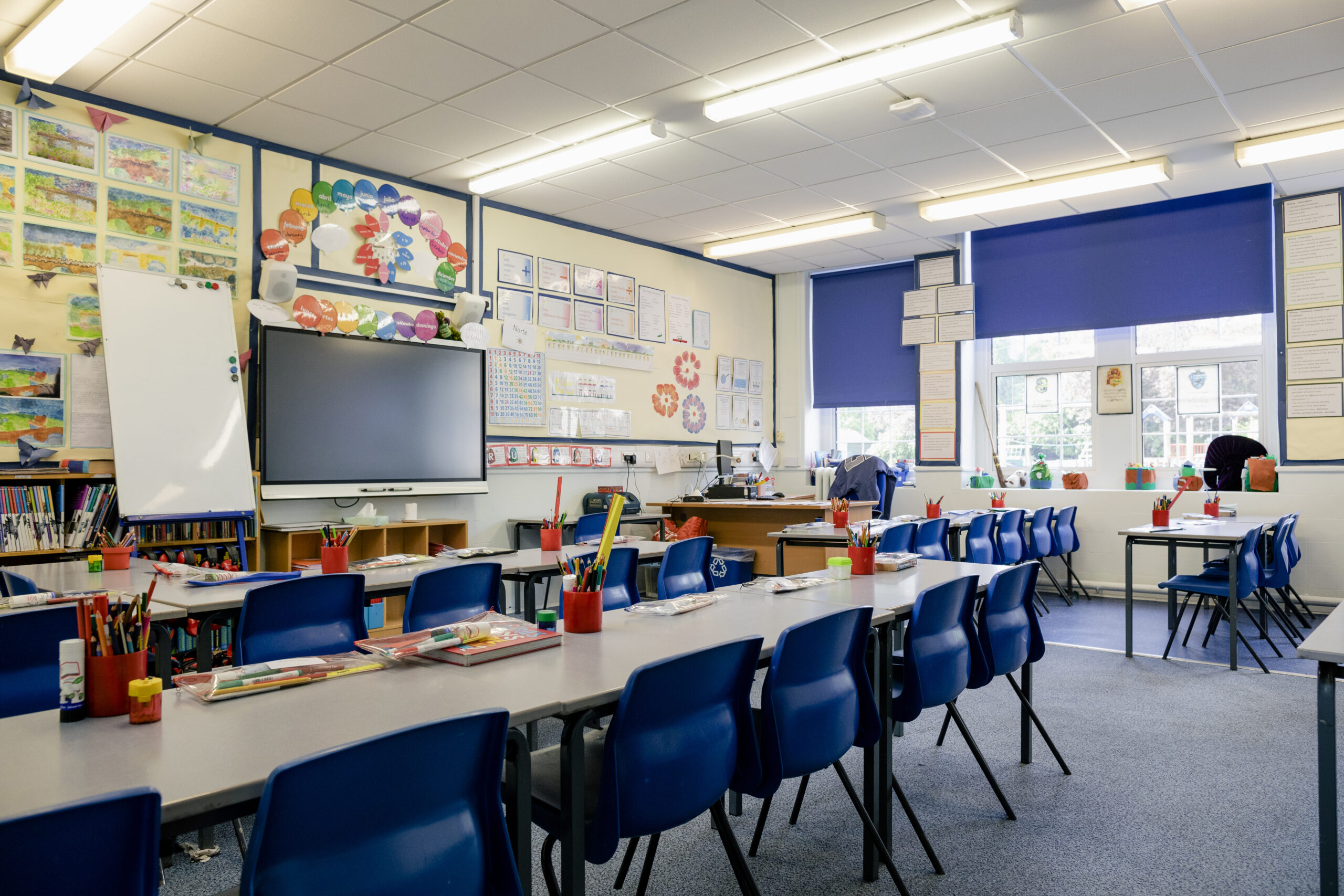 A wide angle view of an organised and tidy classroom in a school